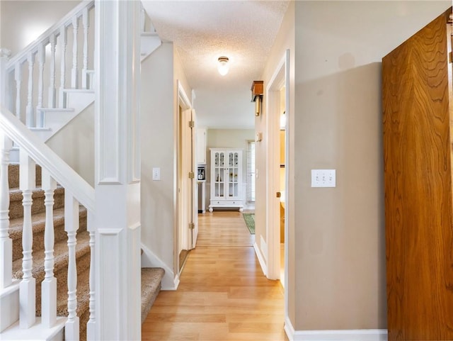 5020 Bayberry Dr, Cumming, GA 30040 - hallway with stairs, light wood finished floors, and a textured ceiling