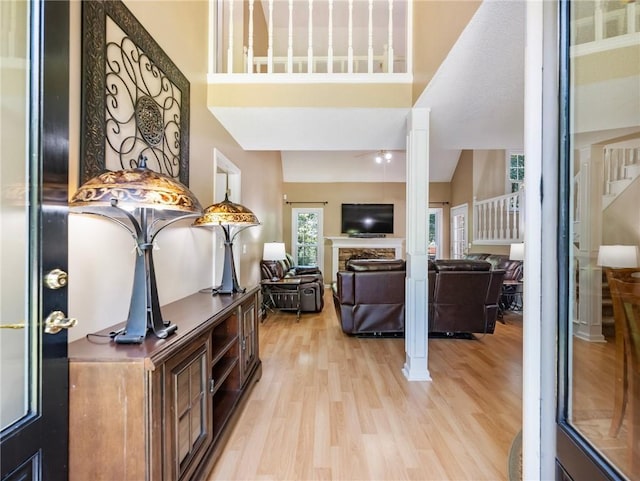 5020 Bayberry Dr, Cumming, GA 30040 - entrance foyer featuring light wood finished floors, ceiling fan, a towering ceiling, stairs, and a fireplace