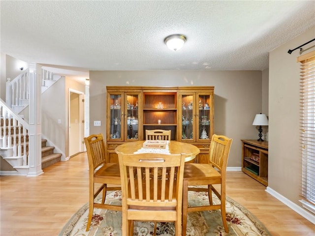 5020 Bayberry Dr, Cumming, GA 30040 - dining area with stairs, light wood-type flooring, and a textured ceiling