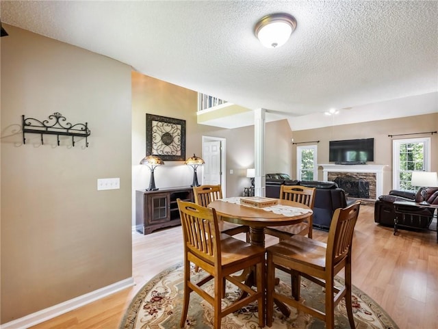 5020 Bayberry Dr, Cumming, GA 30040 - dining area featuring a fireplace, a textured ceiling, and light wood-type flooring