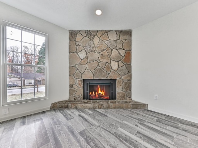 unfurnished living room featuring a fireplace and light hardwood / wood-style floors