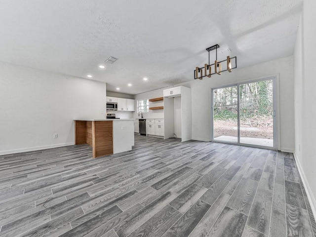 unfurnished living room featuring light hardwood / wood-style floors and a textured ceiling