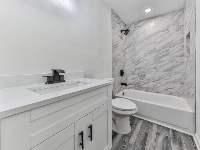 full bathroom featuring vanity, tiled shower / bath combo, and toilet