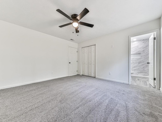 interior space featuring carpet, connected bathroom, and ceiling fan