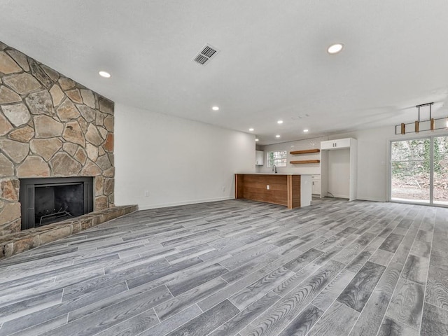 unfurnished living room with a fireplace and light wood-type flooring