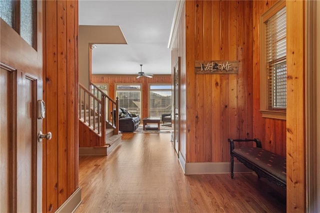 hall with hardwood / wood-style flooring and wooden walls