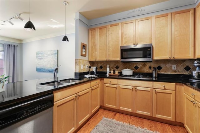 kitchen with tasteful backsplash, sink, decorative light fixtures, kitchen peninsula, and stainless steel appliances