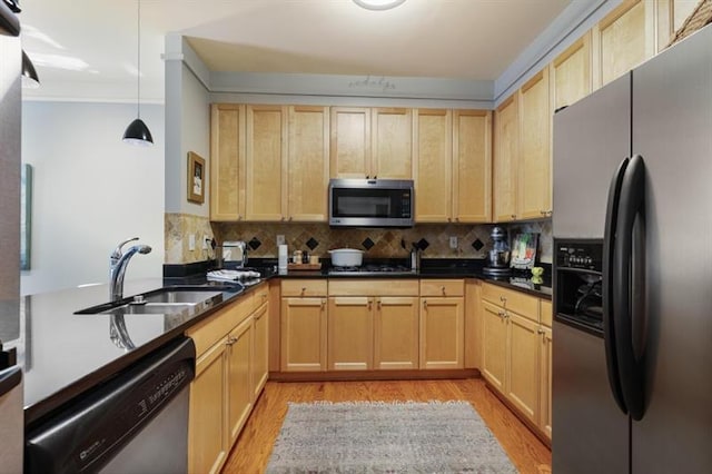 kitchen with sink, stainless steel appliances, light brown cabinetry, and pendant lighting