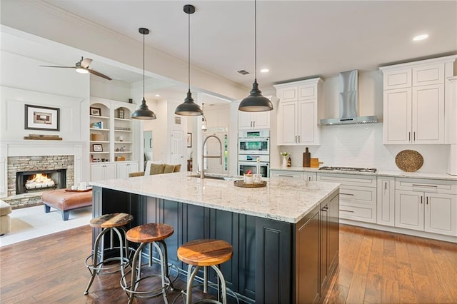 410 Longwood Ln, Alpharetta, GA 30004 - kitchen with wall chimney exhaust hood, appliances with stainless steel finishes, a sink, open floor plan, and white cabinets