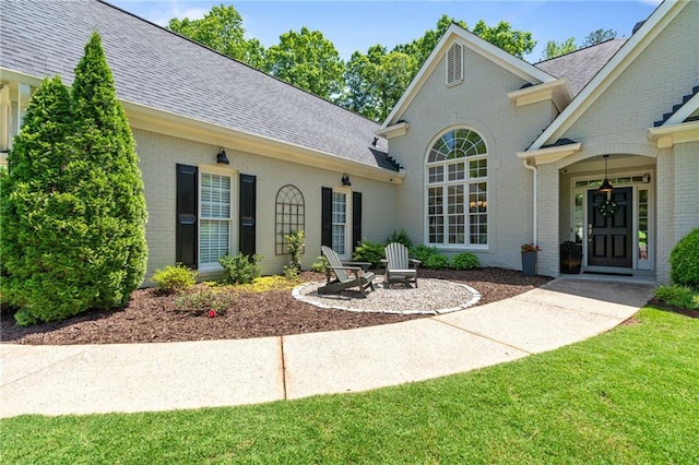 410 Longwood Ln, Alpharetta, GA 30004 - view of exterior entry with brick siding, roof with shingles, and a yard