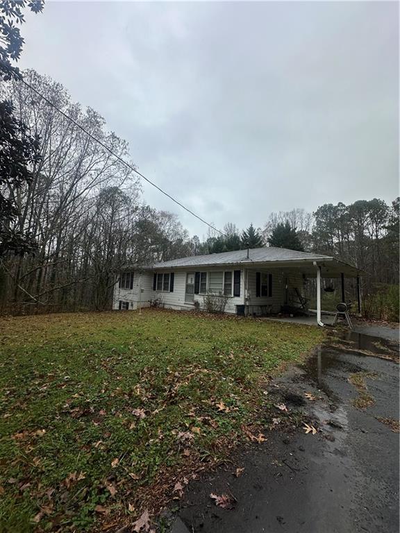 view of front of property with a front yard and a carport