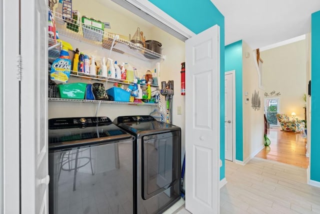 laundry area featuring laundry area, wood finished floors, independent washer and dryer, and baseboards