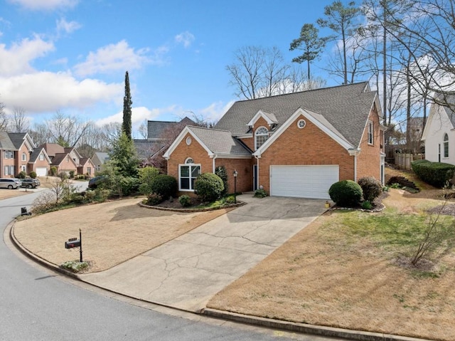 view of front facade with a residential view, brick siding, an attached garage, and driveway