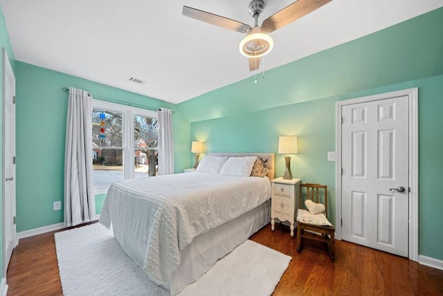 bedroom featuring lofted ceiling, wood finished floors, visible vents, and baseboards