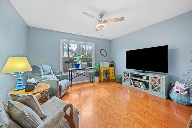 living area featuring ceiling fan, visible vents, and wood finished floors