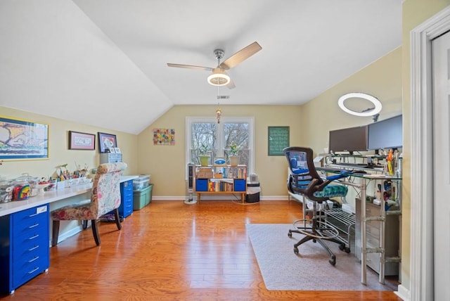 office featuring visible vents, baseboards, lofted ceiling, light wood-style floors, and a ceiling fan