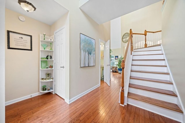 stairway with hardwood / wood-style floors and baseboards