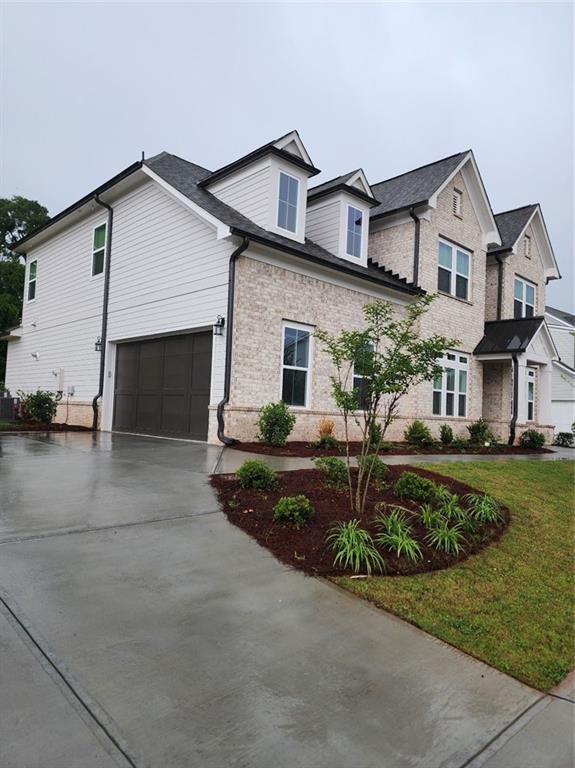 2949 Longbush, Duluth, GA 30097 - view of front facade with concrete driveway, brick siding, an attached garage, and a front lawn