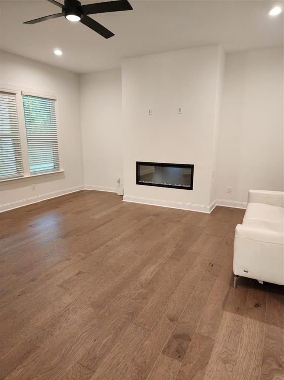 2949 Longbush, Duluth, GA 30097 - living room featuring dark wood-style floors, a glass covered fireplace, recessed lighting, a ceiling fan, and baseboards