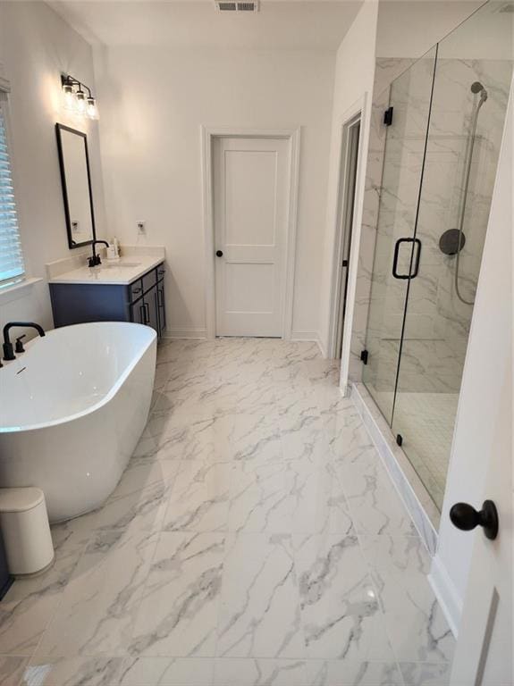 2949 Longbush, Duluth, GA 30097 - bathroom featuring marble look tile flooring, a marble finish shower, a soaking tub, vanity, and baseboards