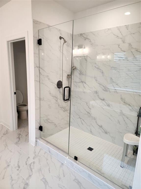2949 Longbush, Duluth, GA 30097 - full bath featuring marble look tile flooring, a marble finish shower, toilet, and baseboards