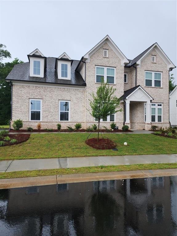 2949 Longbush, Duluth, GA 30097 - view of front of house featuring brick siding, a front yard, and a water view
