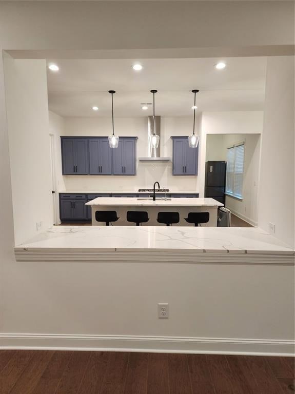 2949 Longbush, Duluth, GA 30097 - kitchen with wall chimney range hood, light countertops, recessed lighting, pendant lighting, and a peninsula
