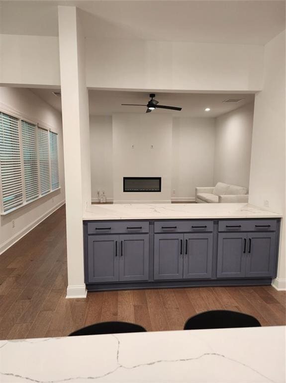 2949 Longbush, Duluth, GA 30097 - kitchen with wood finished floors, gray cabinetry, a ceiling fan, baseboards, and light stone counters