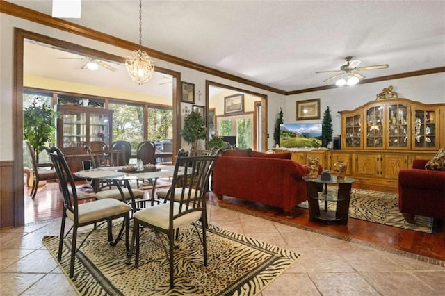 dining room with ceiling fan with notable chandelier and ornamental molding