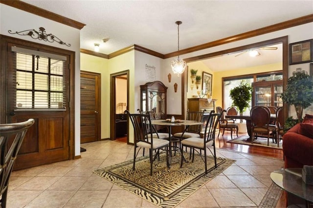 tiled dining space featuring a chandelier, vaulted ceiling, and crown molding