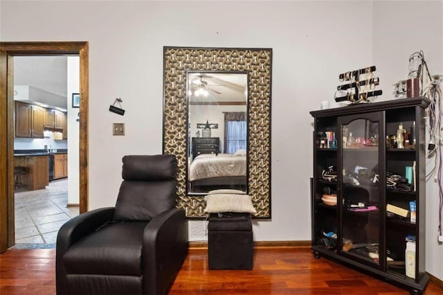 sitting room with ceiling fan and dark hardwood / wood-style flooring