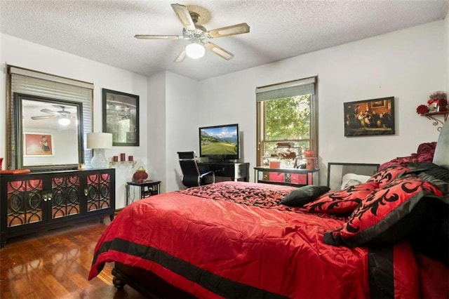 bedroom with ceiling fan, a textured ceiling, and dark hardwood / wood-style flooring