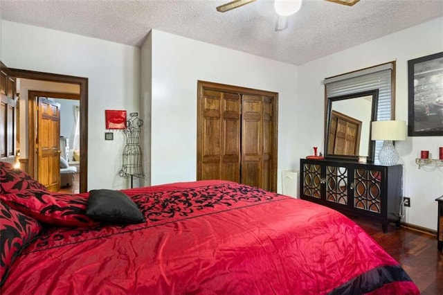 bedroom with ceiling fan, a textured ceiling, and dark wood-type flooring