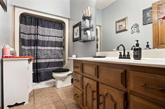 bathroom with tile patterned flooring, curtained shower, vanity, and toilet