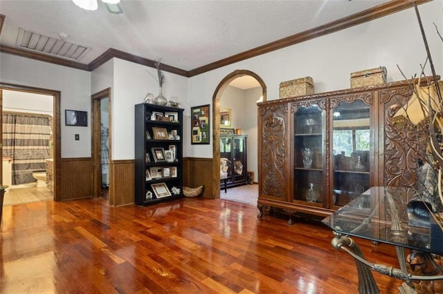 interior space featuring ornamental molding, wooden walls, and hardwood / wood-style floors