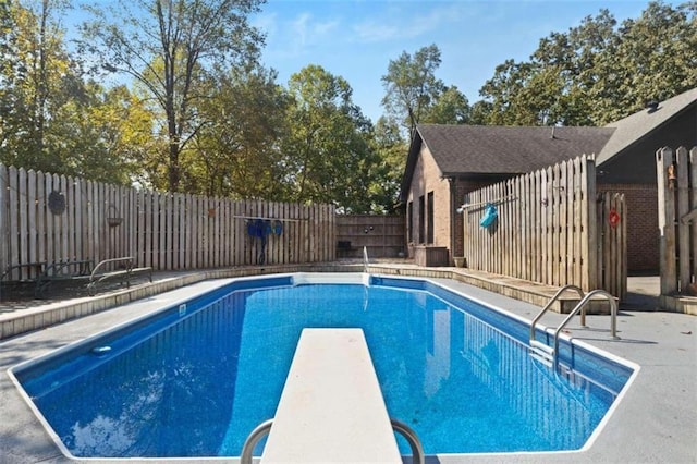 view of pool with a diving board