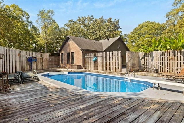 view of swimming pool with a deck and a diving board