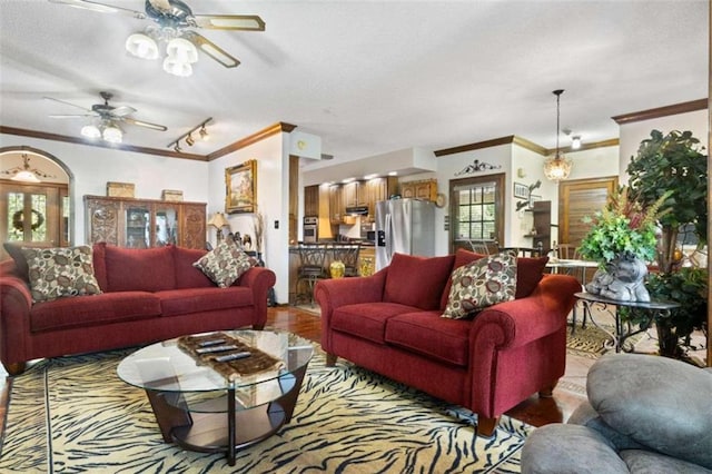 living room with crown molding, light hardwood / wood-style floors, and ceiling fan