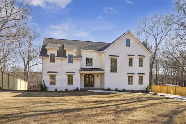 modern inspired farmhouse with fence, a standing seam roof, a front lawn, french doors, and board and batten siding