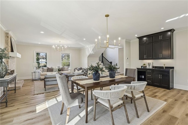 dining room with stairs, light wood-style flooring, ornamental molding, and a chandelier