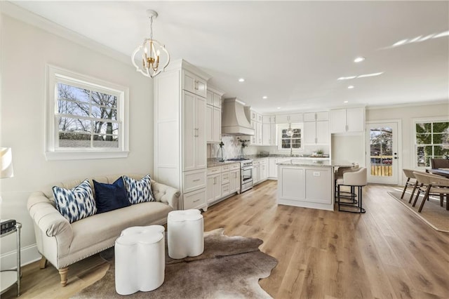 interior space with premium range hood, light wood-type flooring, and white cabinets