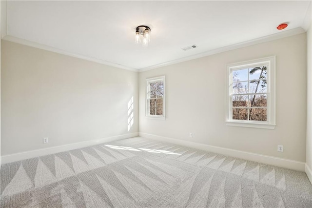 empty room with a wealth of natural light, baseboards, carpet, and crown molding