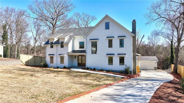 modern farmhouse style home featuring fence, a chimney, an outdoor structure, french doors, and board and batten siding