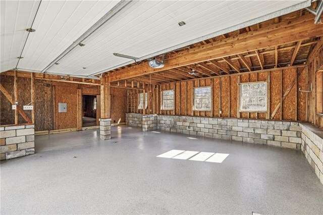 garage featuring concrete block wall and a garage door opener