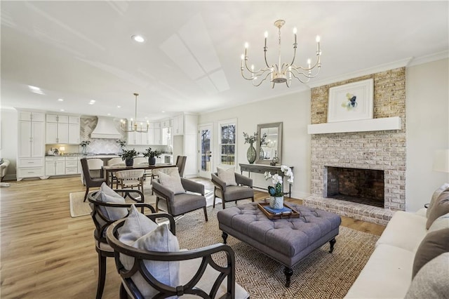 living area featuring light wood finished floors, a fireplace, recessed lighting, crown molding, and a notable chandelier