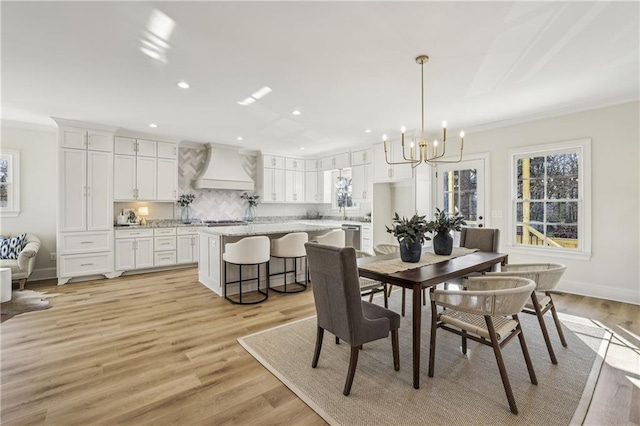 dining space with recessed lighting, light wood-style flooring, and ornamental molding