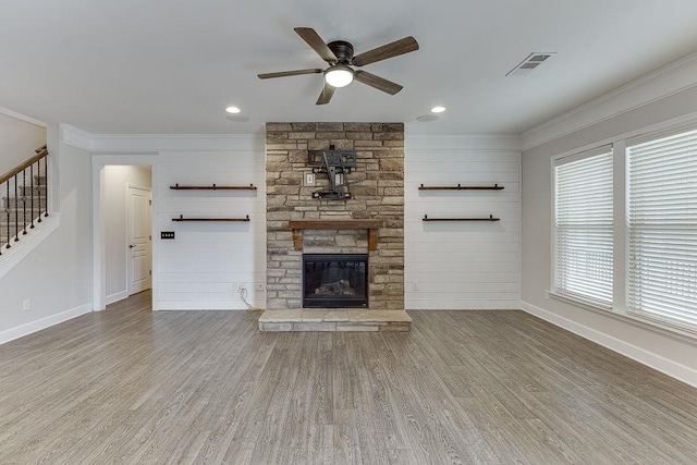 unfurnished living room featuring ornamental molding, wood finished floors, visible vents, and ceiling fan