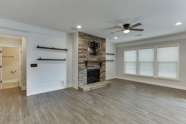 unfurnished living room with visible vents, ornamental molding, a ceiling fan, wood finished floors, and a fireplace