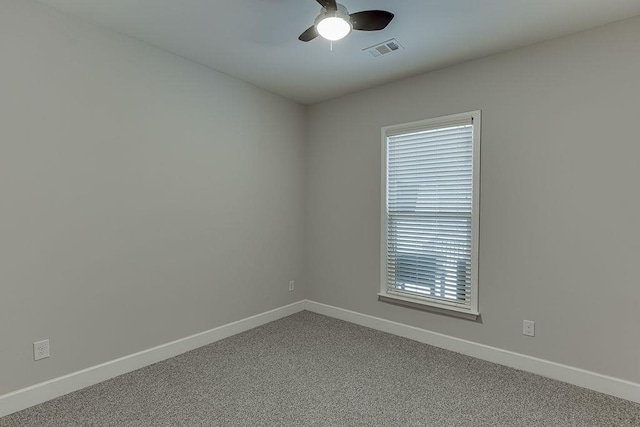 spare room with visible vents, carpet flooring, baseboards, and ceiling fan