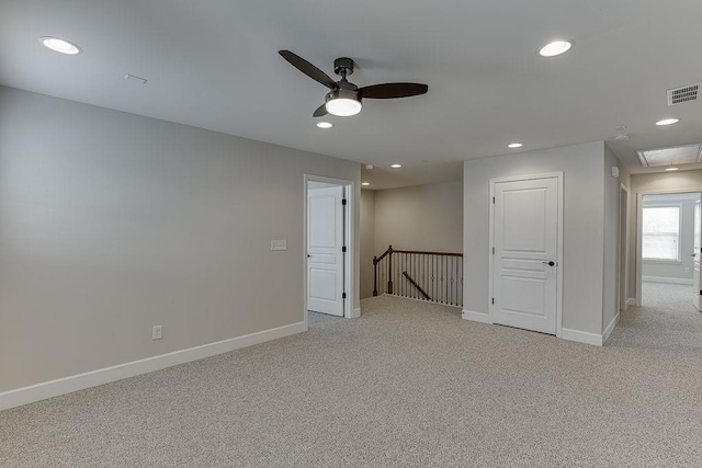 unfurnished room with baseboards, light colored carpet, visible vents, and ceiling fan